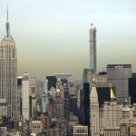 2-people-climb-to-the-top-of-empire-state-building-spire,-unfurl-banner