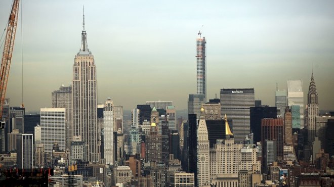 2-people-climb-to-the-top-of-empire-state-building-spire,-unfurl-banner